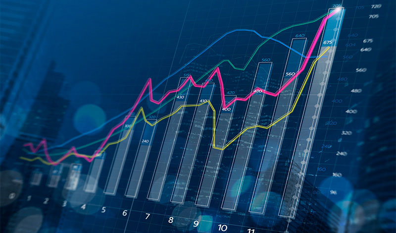 Financial bar chart and growing graphs with depth of field on dark blue background