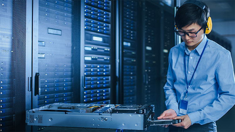 Worker performing maintenance on a server utilizing VCSEL technology