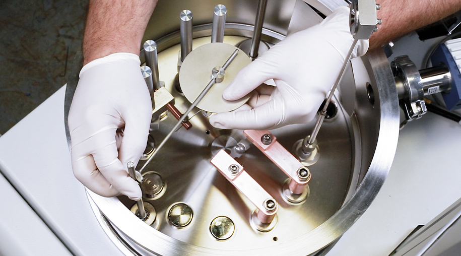 Engineer with hands inside the benchtop turbo system from denton vacuum